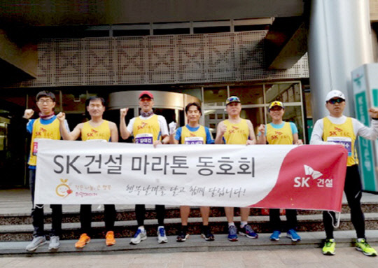 SK건설 마라톤 동호회 회원 및 임직원들이 지난 19일 열린 서울국제마라톤 대회에 참가해 기념촬영을 하고 있다.  SK건설 제공